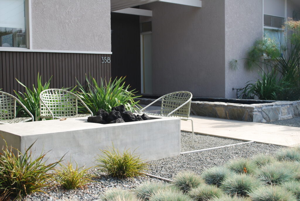 A rectangular fire pit beside patio chairs