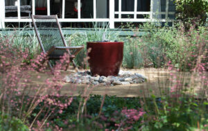 A red water feature surrounded by stones and landscape