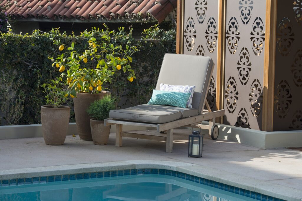 An arrangement of pots by pool furniture